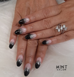 Mint Salon nail technician applying bright summer nail polish with floral designs